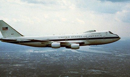 United States Air Force Boeing E-4B in flight over a city