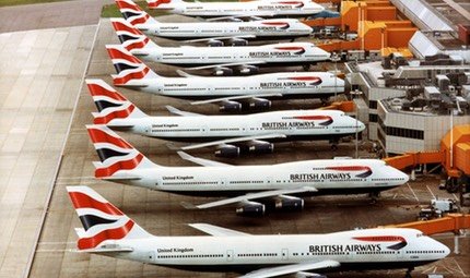 Aerial view of seven British Airways Boeing 747s parked at their gates
